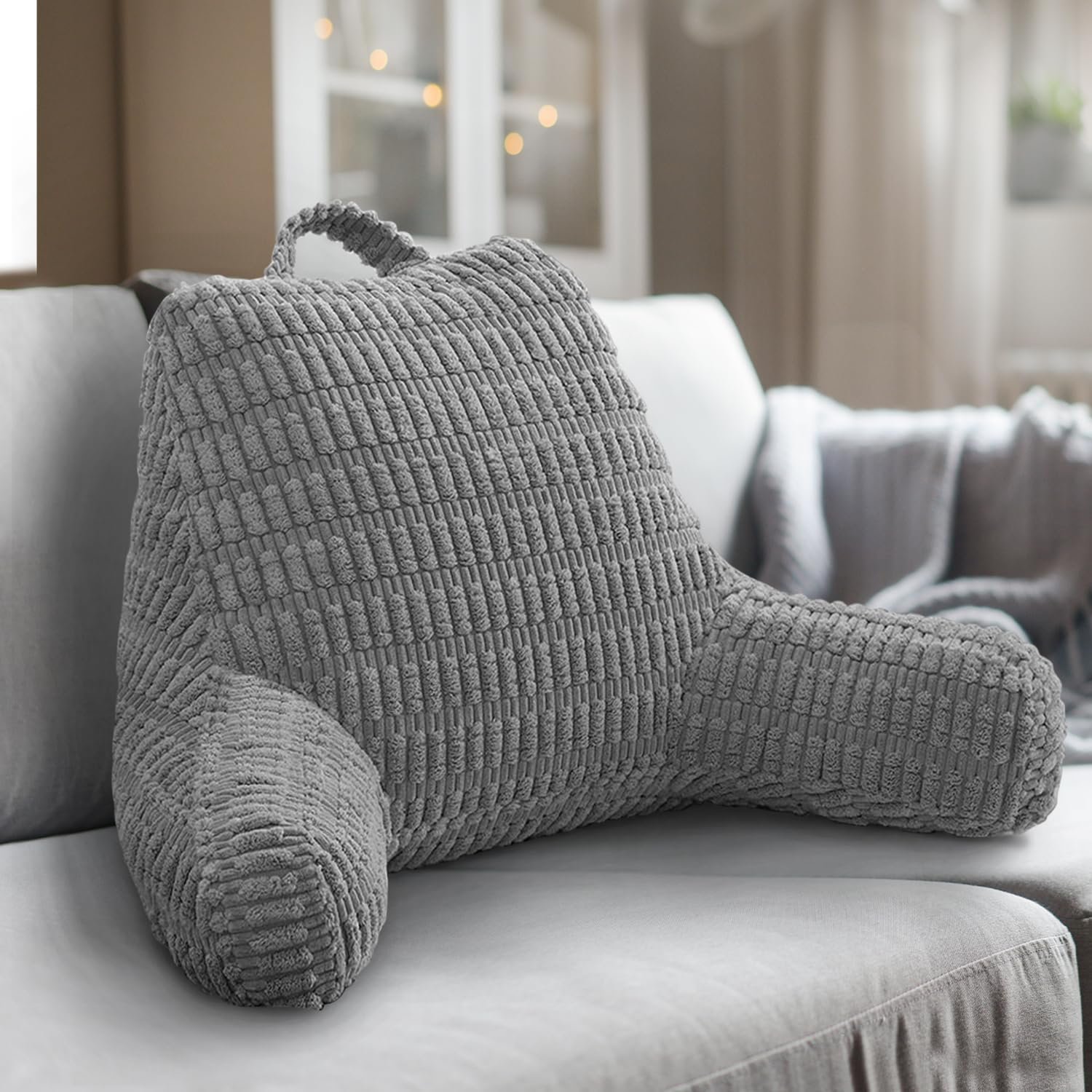 Grey textured backrest pillow on a sofa in a living room